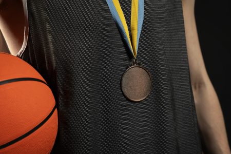 Sportowiec z medalem i piłką