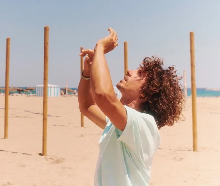 Mężczyzna w koszulce Stanley Stella na tle plaży