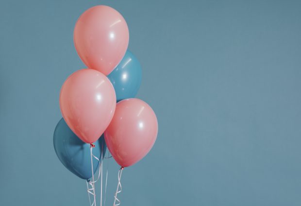 Różowe i niebieskie balony na niebieskim tle