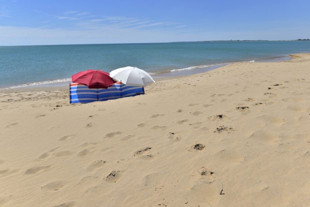 Parawan plażowy i dwie parasolki na plaży