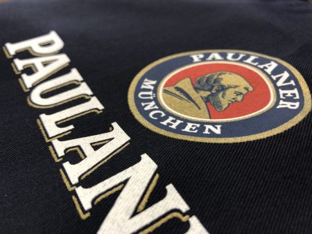 Granatowa tkanina z kolorowym nadrukiem Paulaner Munchen
