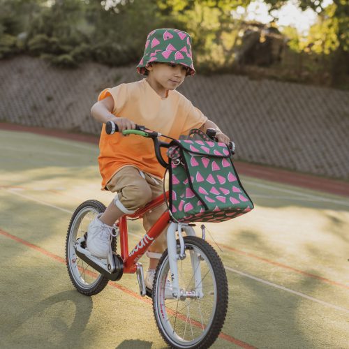 chłopiec w kapeluszu jedzie na rowerze