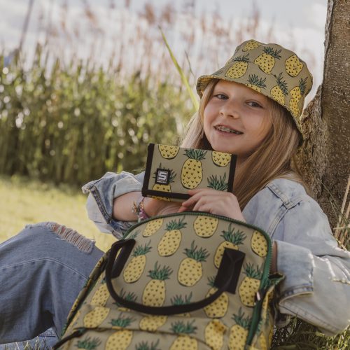 siedząca dziewczynka akcesoriami w ananasy