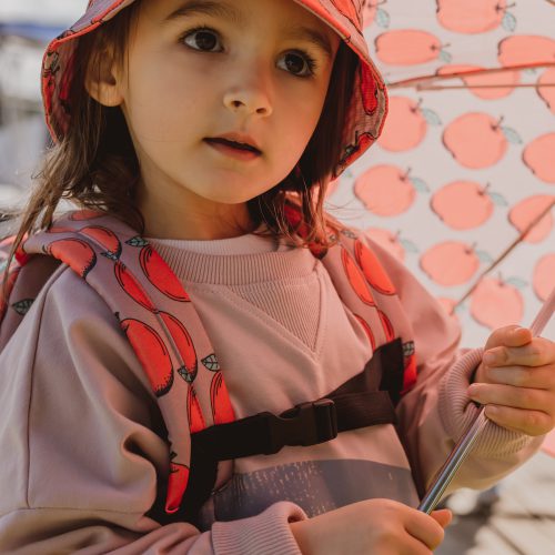 dziewczynka z plecakiem i parasolką w jabłuszka