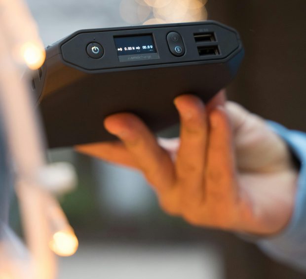 Osoba trzyma czarny powerbank w dłoni