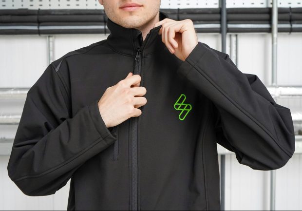 Mężczyzna zapinający czarną kurtkę softshell
